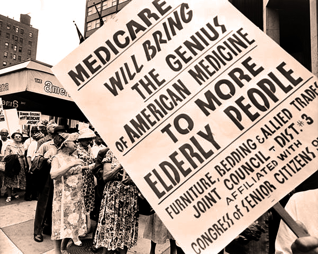 A black and white photo showing a protest sign with bold text, capturing the spirit of activism and social change.